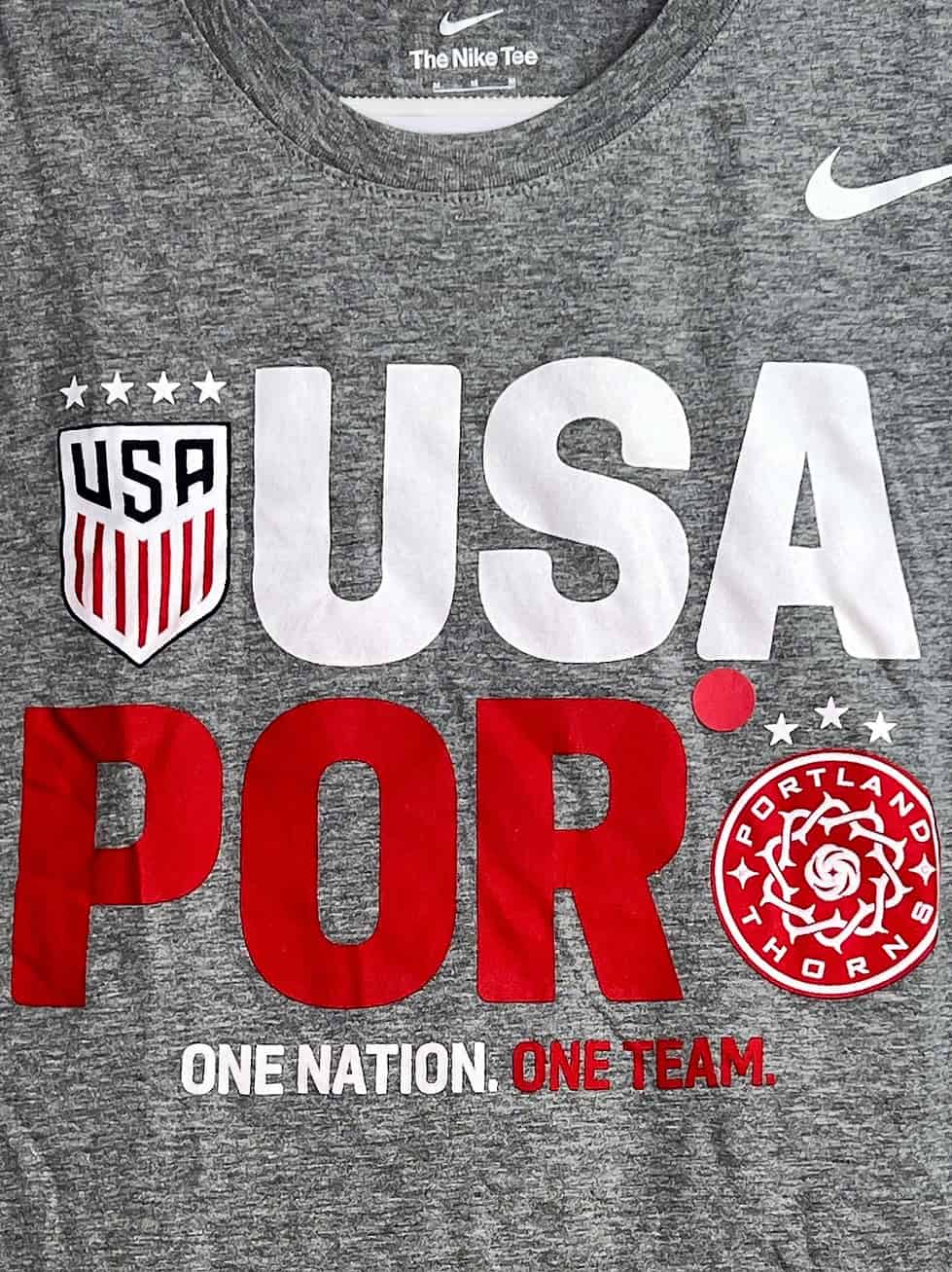 Close-up of USWNT and Portland Thorns logos with “One Nation. One Team.” tagline