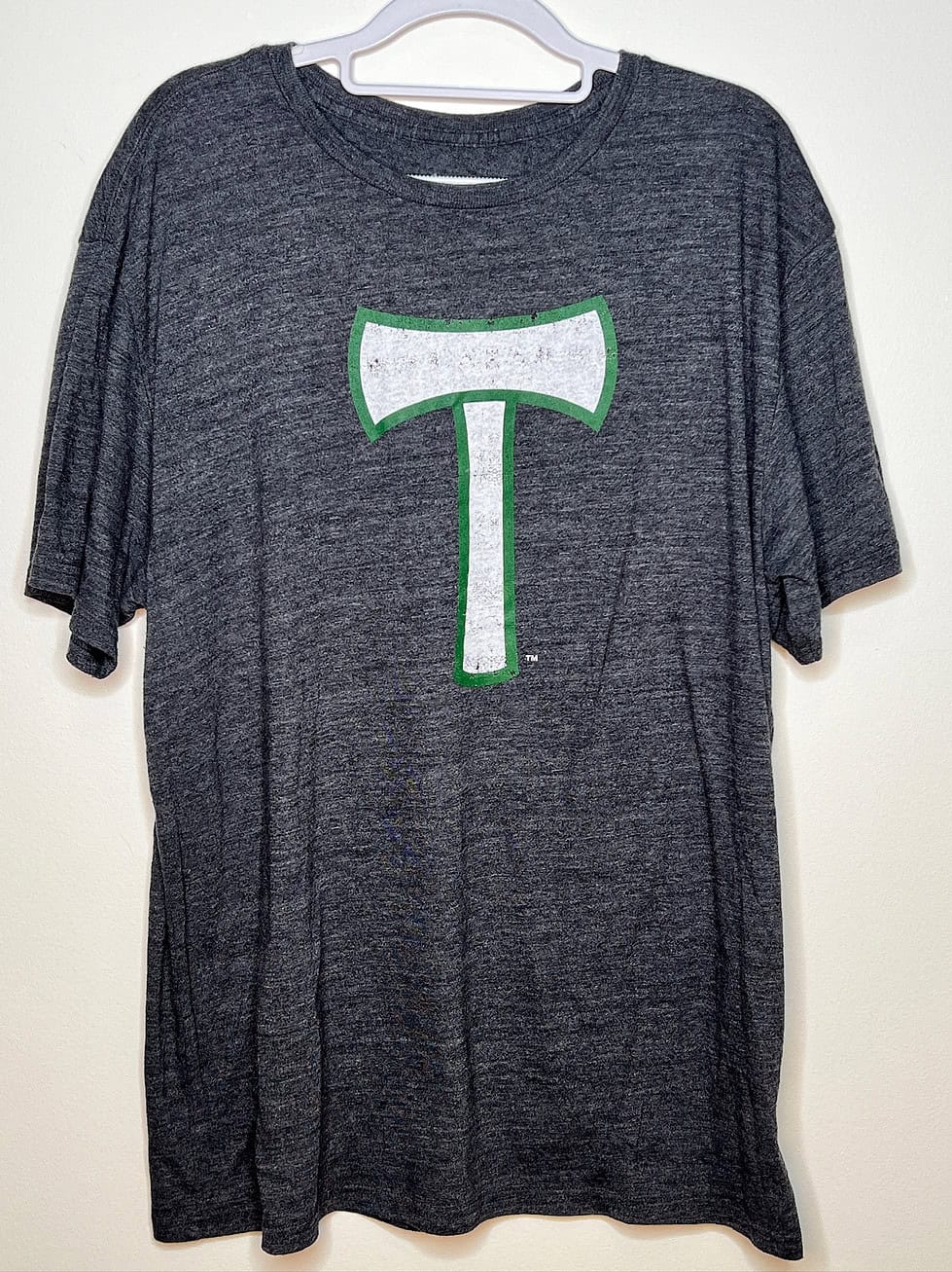 Front of shirt. Dark heather grey with white and green t-axe logo