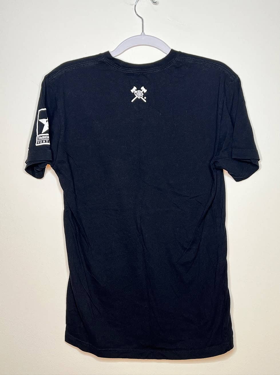 Back of t-shirt with two small crossed axes near neck