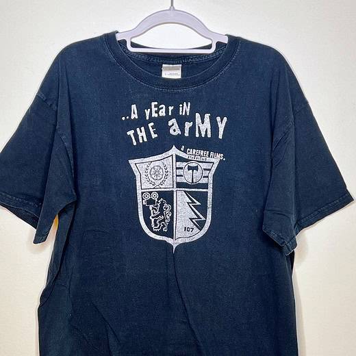 Front view of black Timbers Army “A Year in the Army” tee with crest graphic,