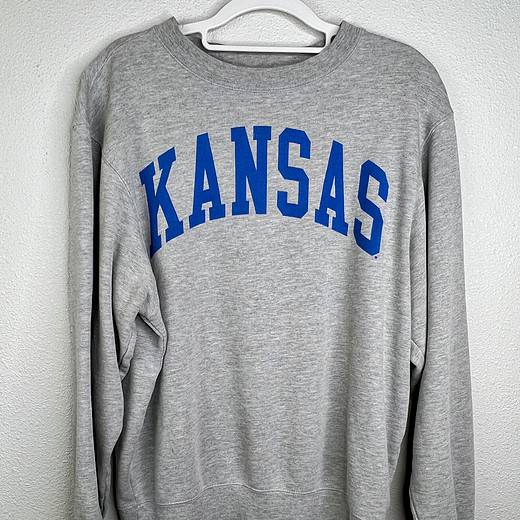 Front view of gray Kansas crewneck sweatshirt featuring blue collegiate-style lettering.