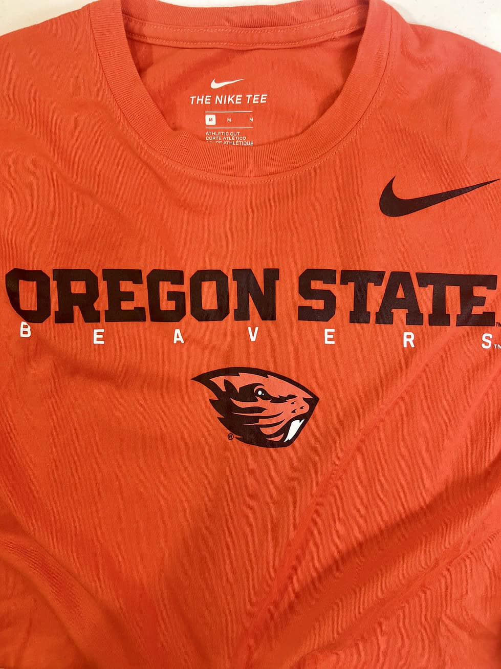 Close-up of Oregon State Beavers logo on Nike Dri-FIT orange t-shirt.