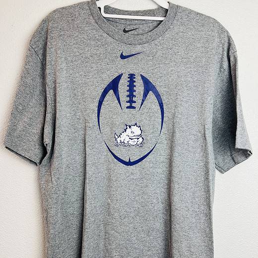 Gray Nike TCU football shirt with purple football graphic and Horned Frog logo on the front,