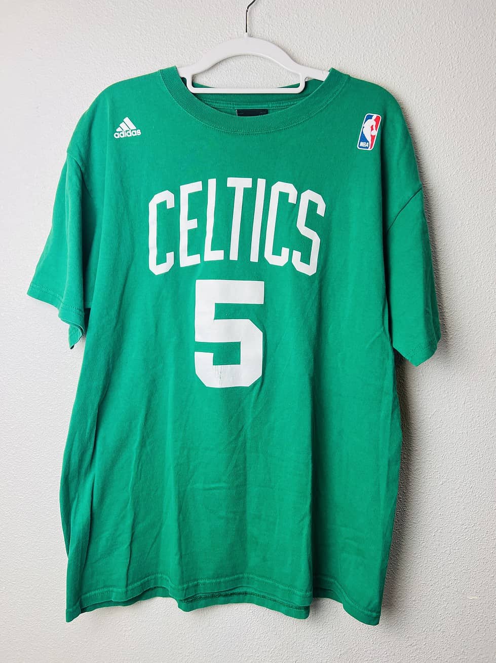 Green Adidas Kevin Garnett Boston Celtics t-shirt with “Celtics” and #5 on the front, and “Garnett” with #5 on the back, size medium.