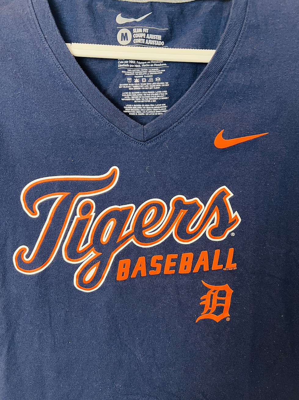 Navy blue Detroit Tigers Nike women’s V-neck t-shirt with “Tigers Baseball” script, Detroit “D” logo, and orange Nike swoosh, size small.