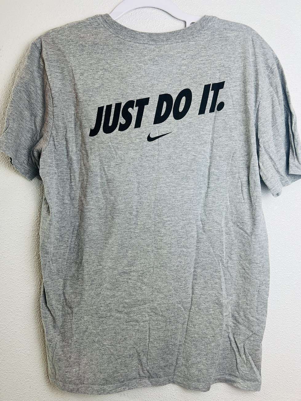 Back of Nike team-issued gray tee with 'Just Do It.' slogan in black.
