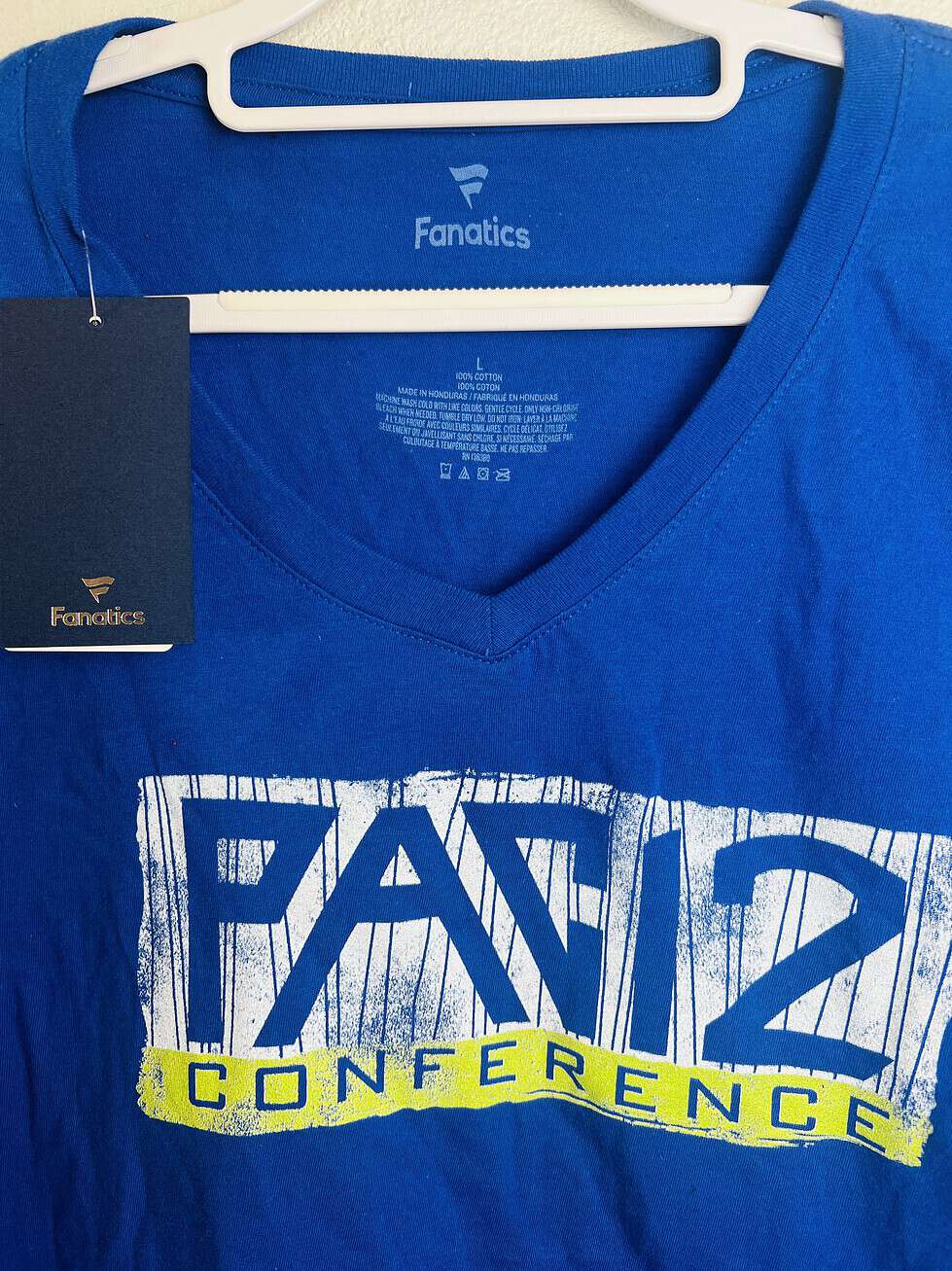 Close-up of Pac-12 Conference logo on Fanatics long-sleeve V-neck shirt.