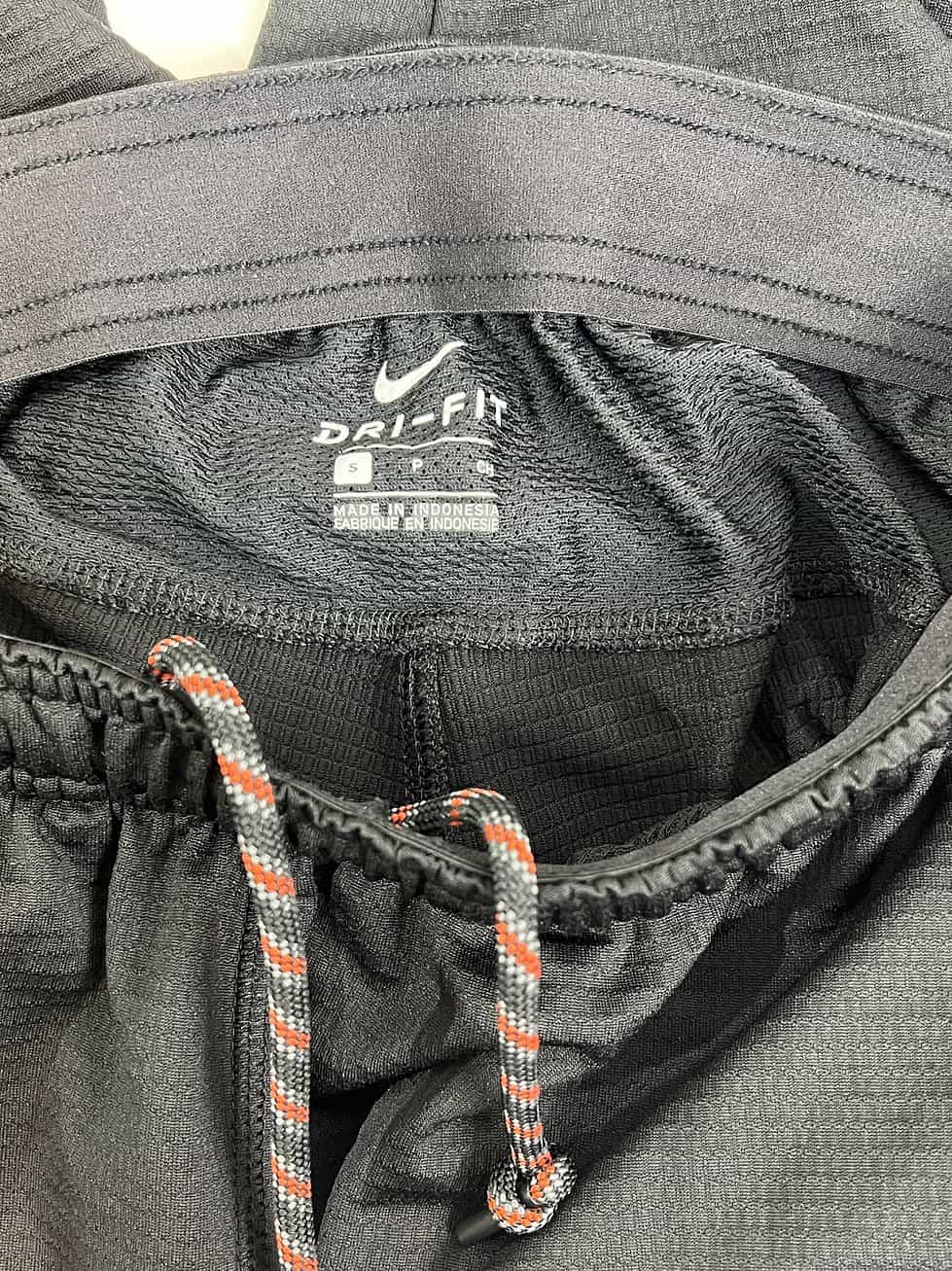 Close-up of elastic waistband and drawstrings on team-issued Nike basketball shorts, size small.