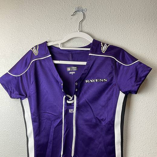 Purple Baltimore Ravens women’s lace-up jersey tee with black and white side panels, embroidered logo on chest and shoulders, size medium.