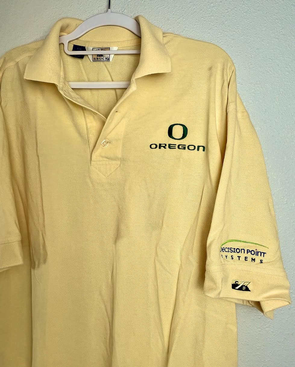 Close-up of embroidered "Oregon" logo on chest and sleeve branding.