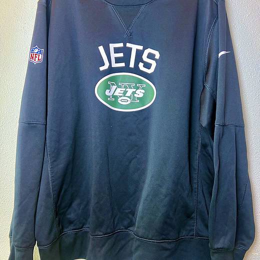 Front of dark gray Nike Jets Therma-FIT sweatshirt with Jets logo and NFL patch.