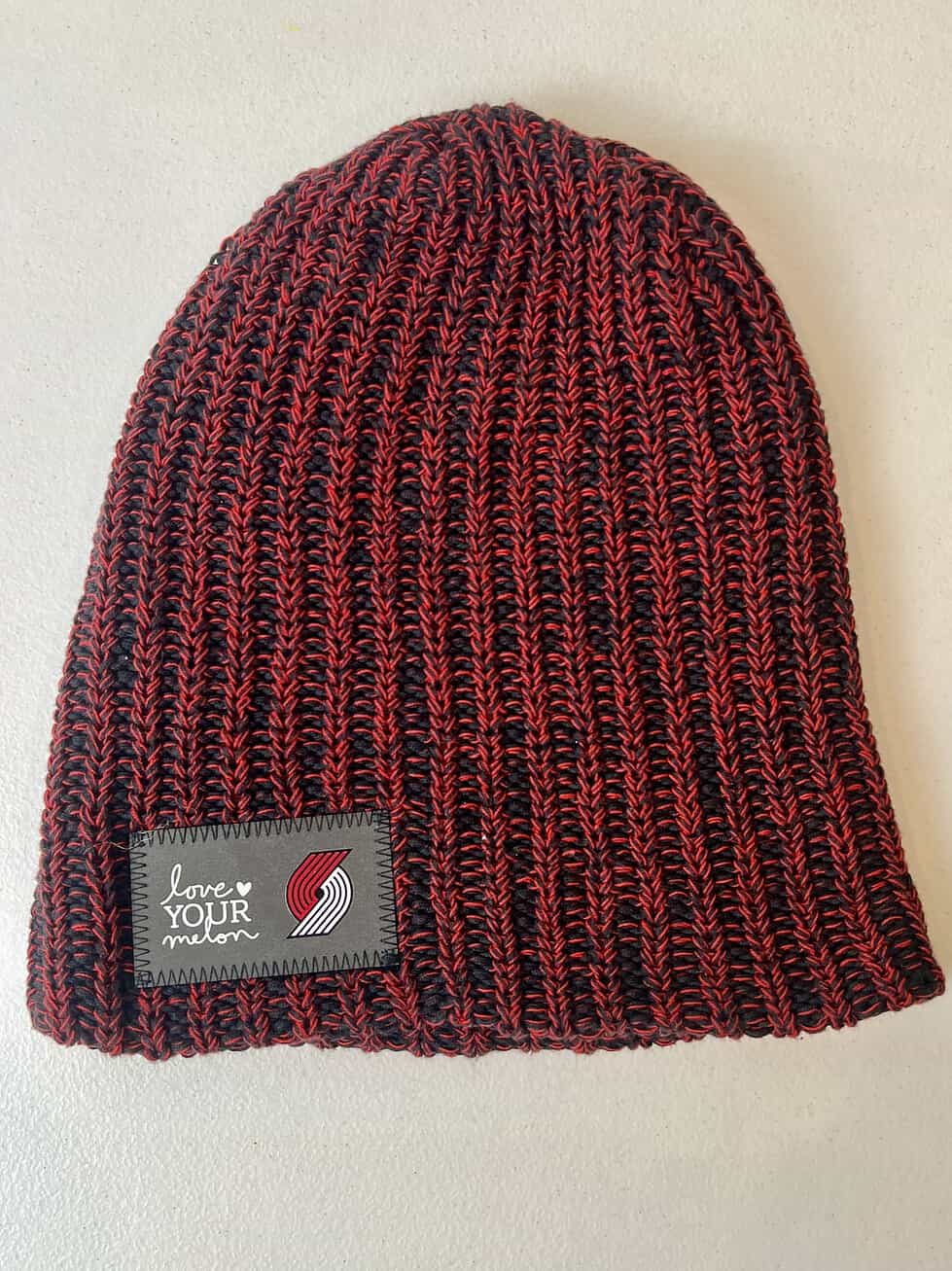 Black and red ribbed Trail Blazers Love Your Melon beanie, front view with no cuff.