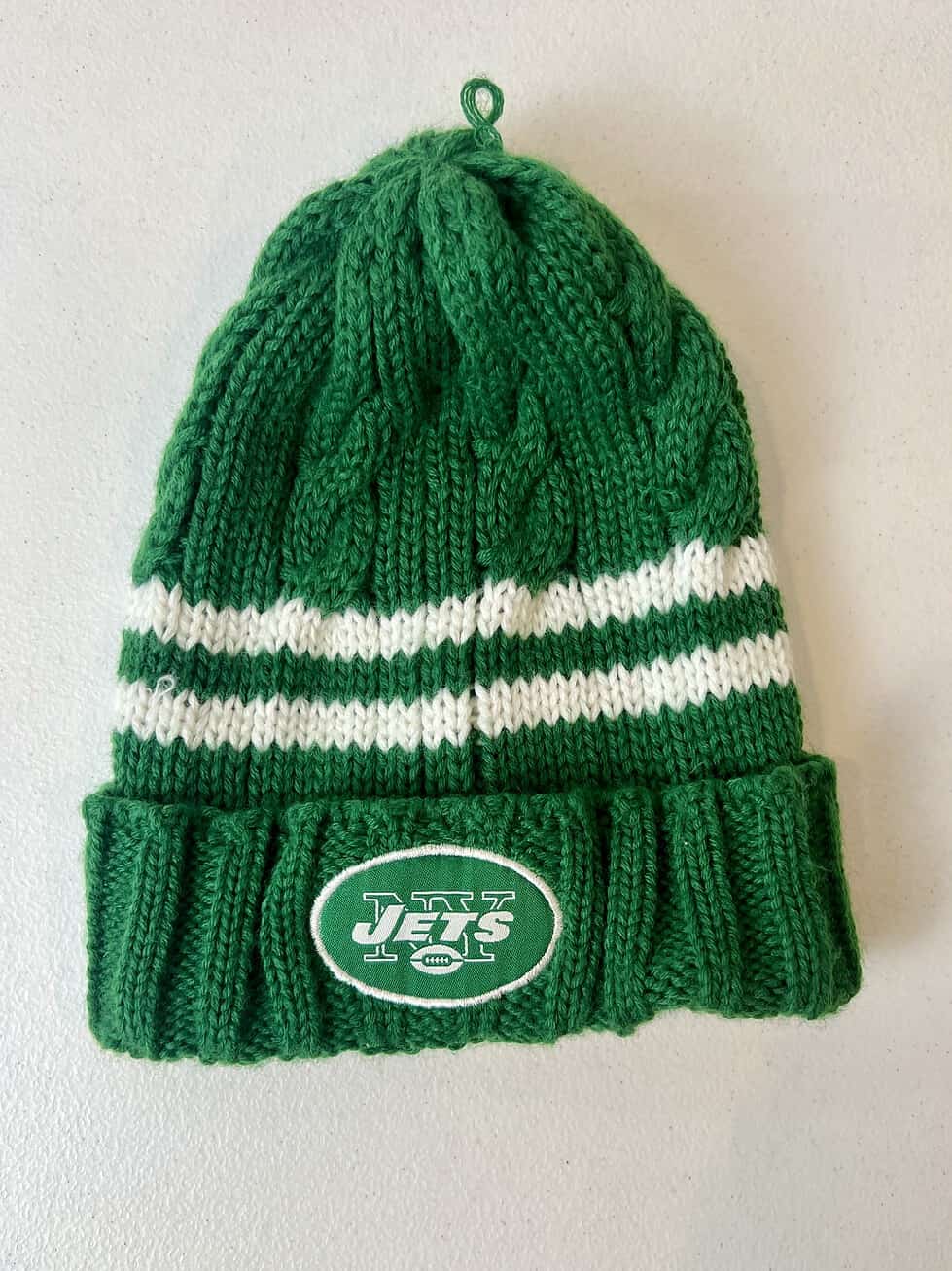 Green and white knit NY Jets kids beanie with striped design and cuffed logo.
