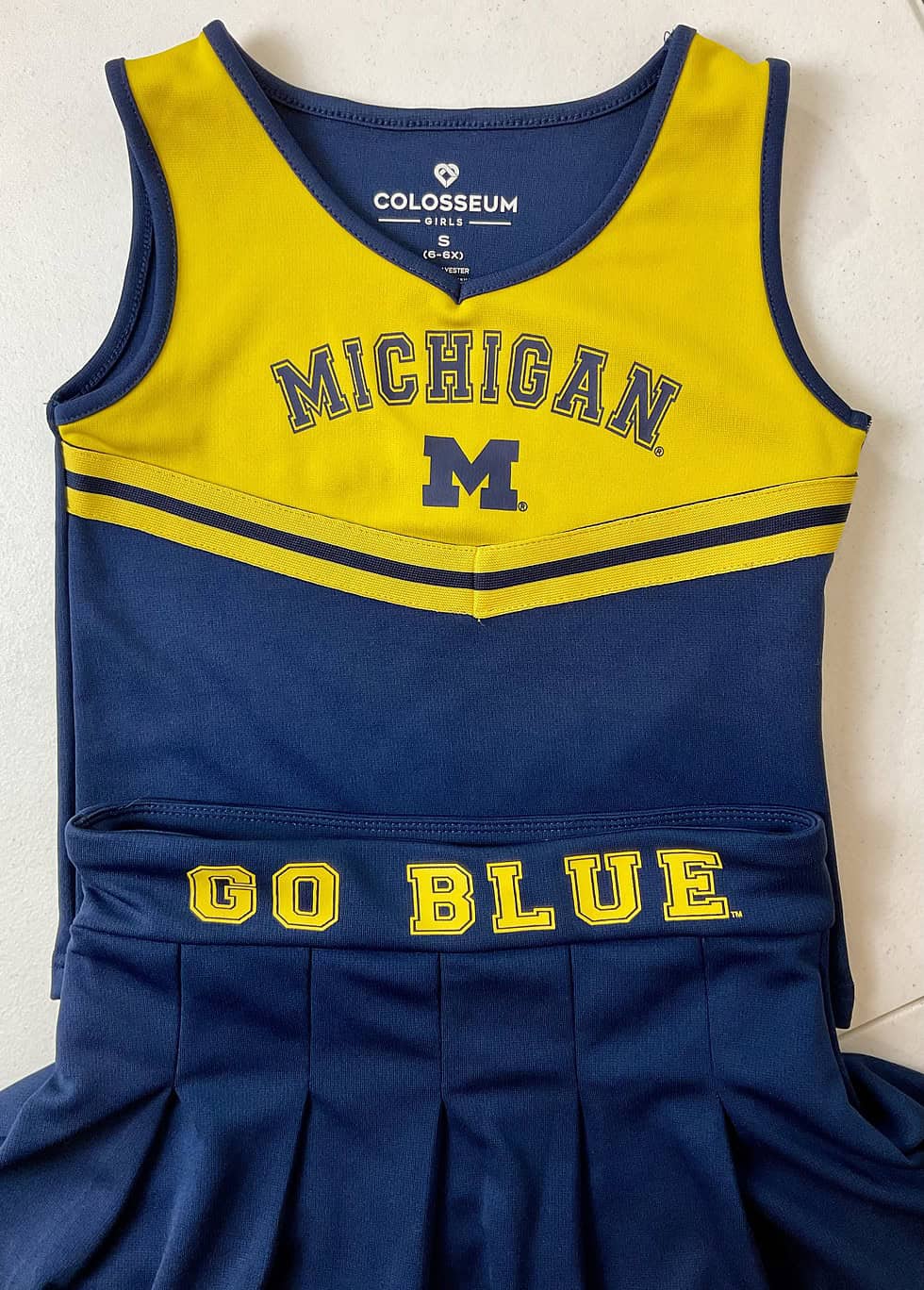 Close-up of “GO BLUE” embroidery on the waistband of the Michigan cheer skirt.