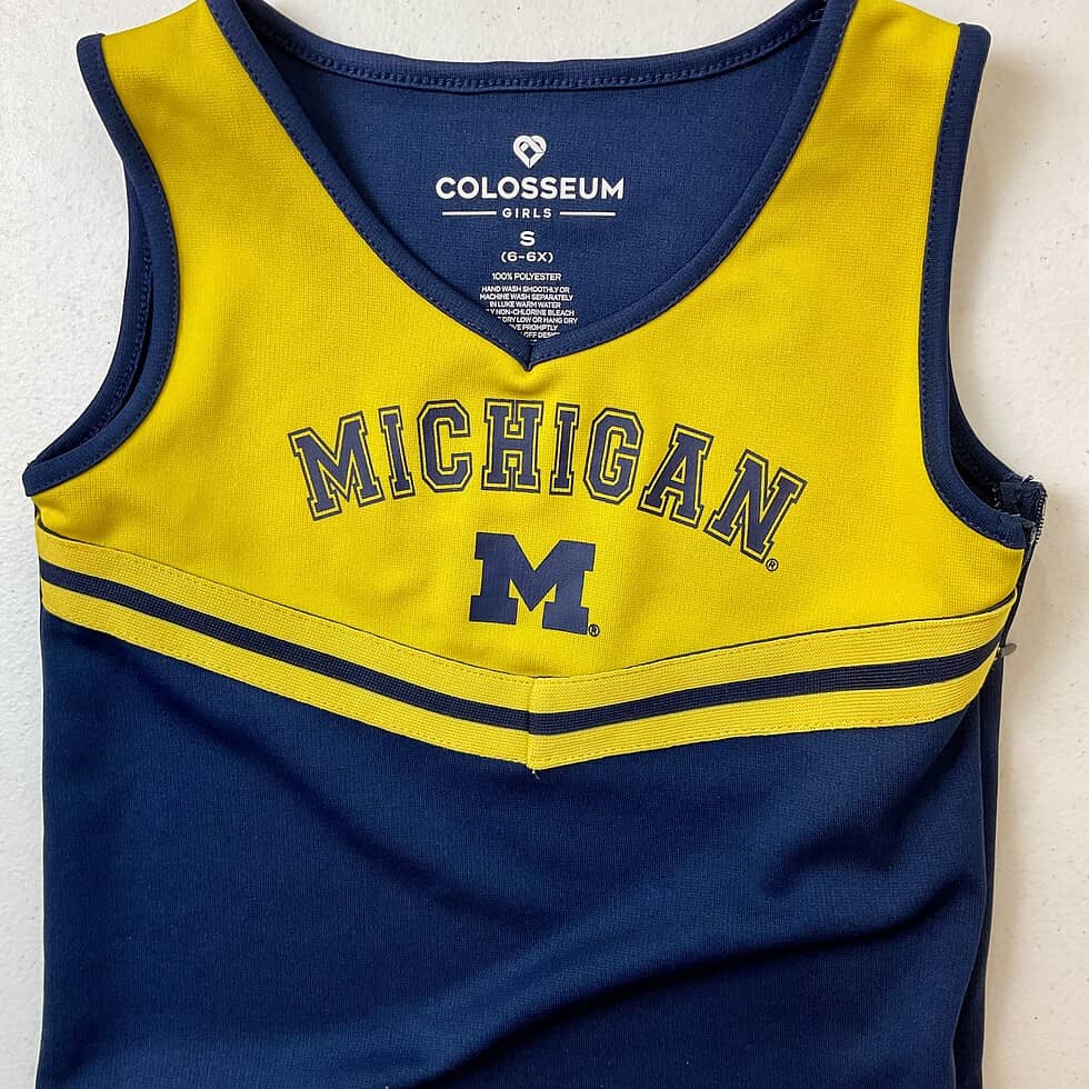 Close-up of Michigan Wolverines girls’ cheerleading top with maize and blue design
