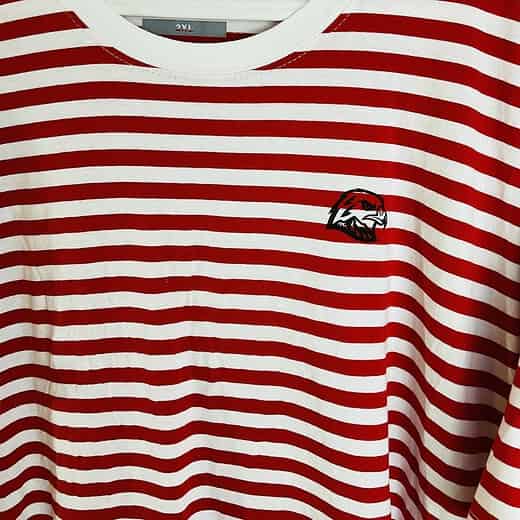 Close-up of Portland Winterhawks embroidered logo on chest of red and white striped t-shirt.