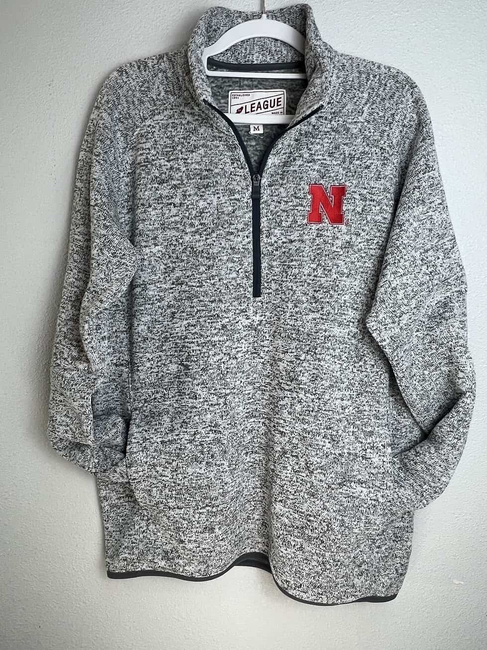 Heathered gray Nebraska Huskers quarter-zip pullover with red “N” logo on front.