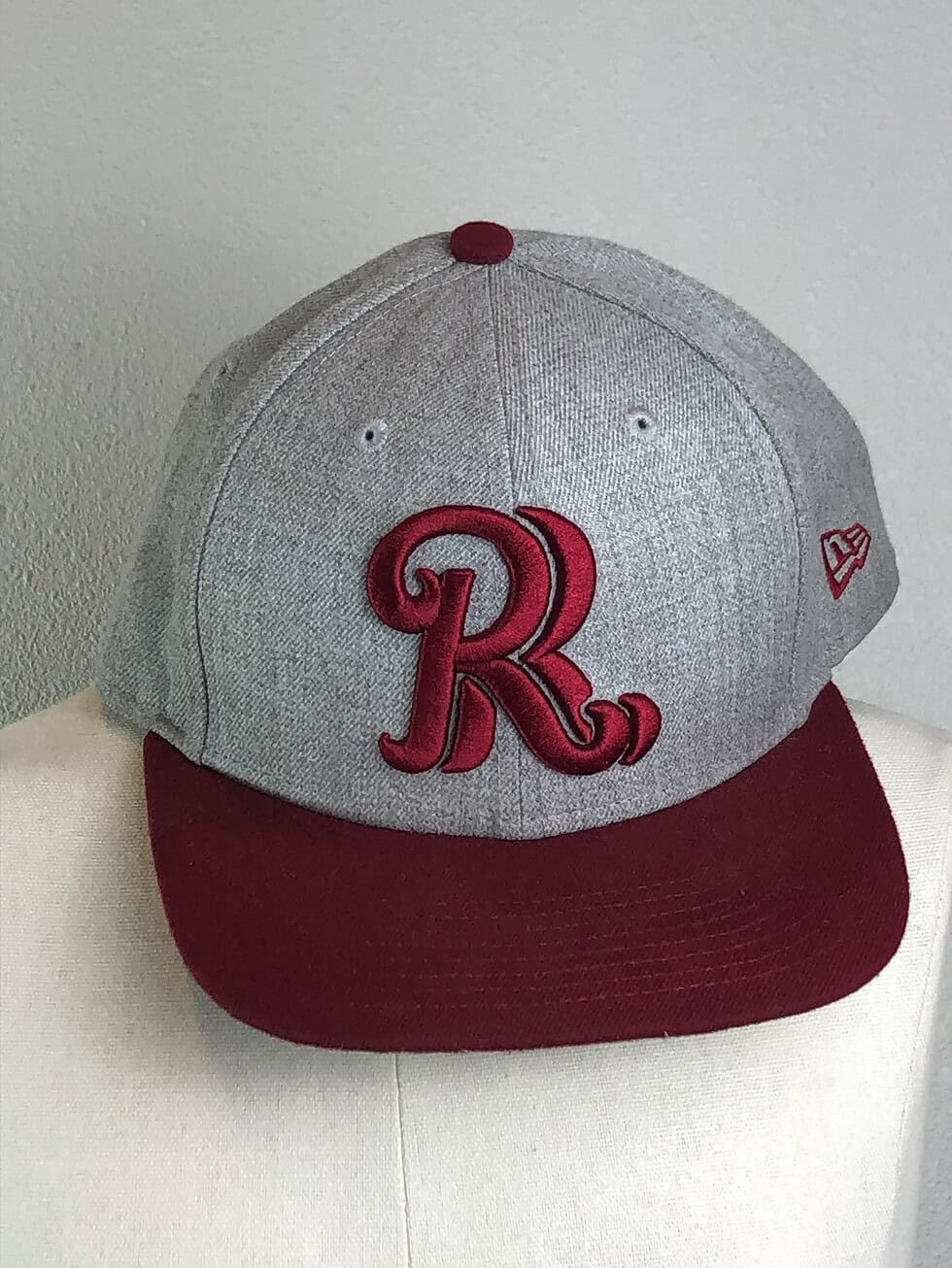 Frisco RoughRiders New Era fitted hat with heather gray crown and burgundy brim, featuring an embroidered script “R” logo on the front.