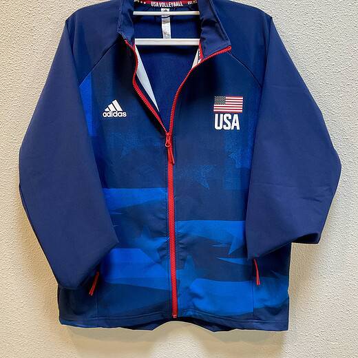 Front view of navy Adidas USA Volleyball jacket with red zipper and USA flag print.