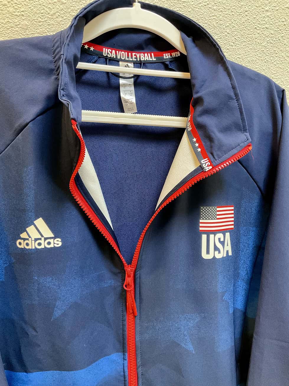 Close-up of Adidas and USA flag logos, red zipper, and USA Volleyball branding inside collar.
