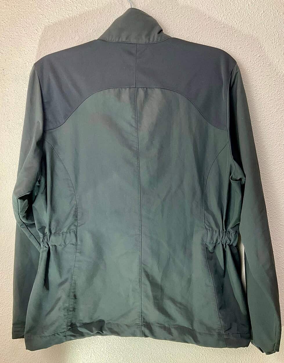 Rear view of black Nike Golf women’s windbreaker showing panel details and fitted waist