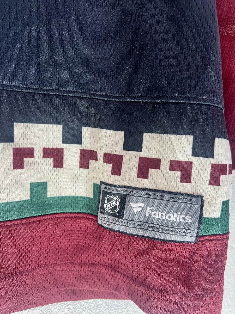 Close-up of Fanatics Breakaway tag and hem graphics on Coyotes Kachina jersey