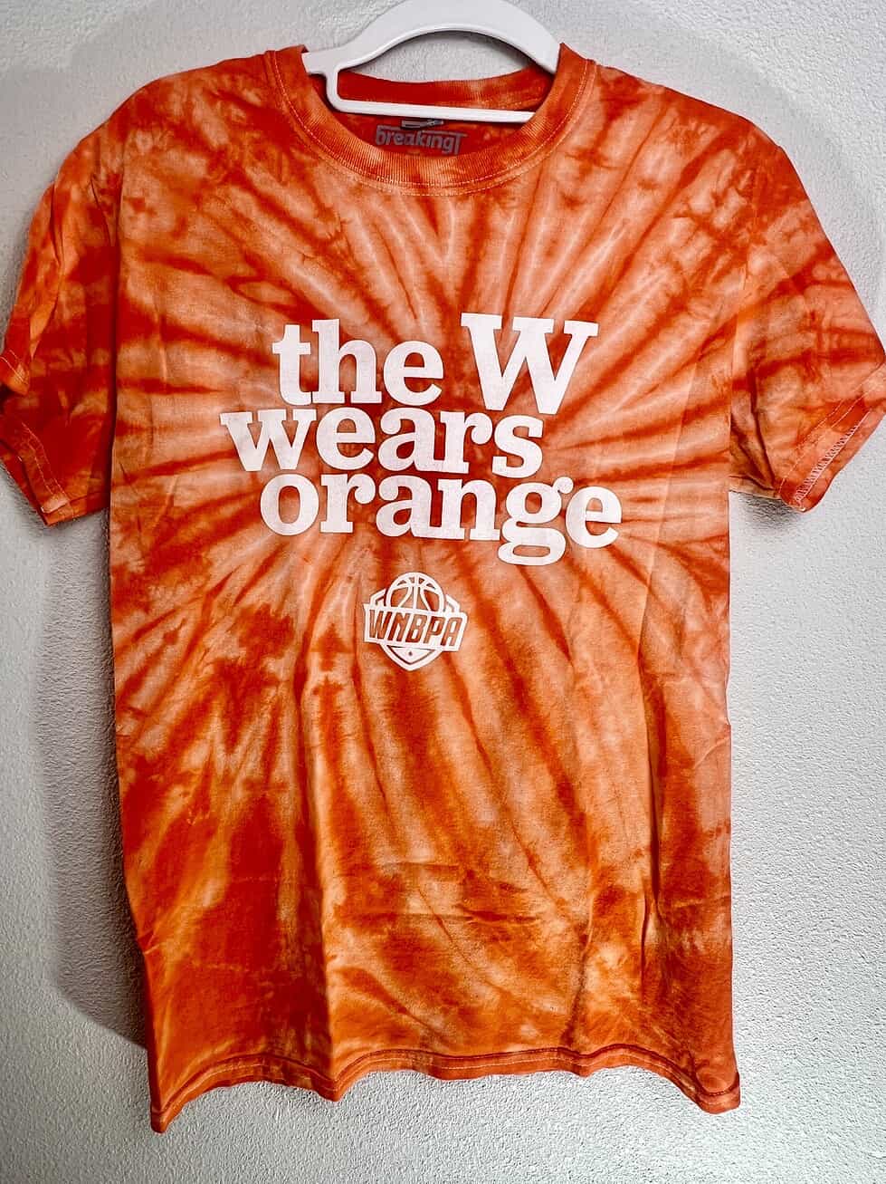 Orange tie-dye BreakingT WNBPA shirt with “The W Wears Orange” graphic