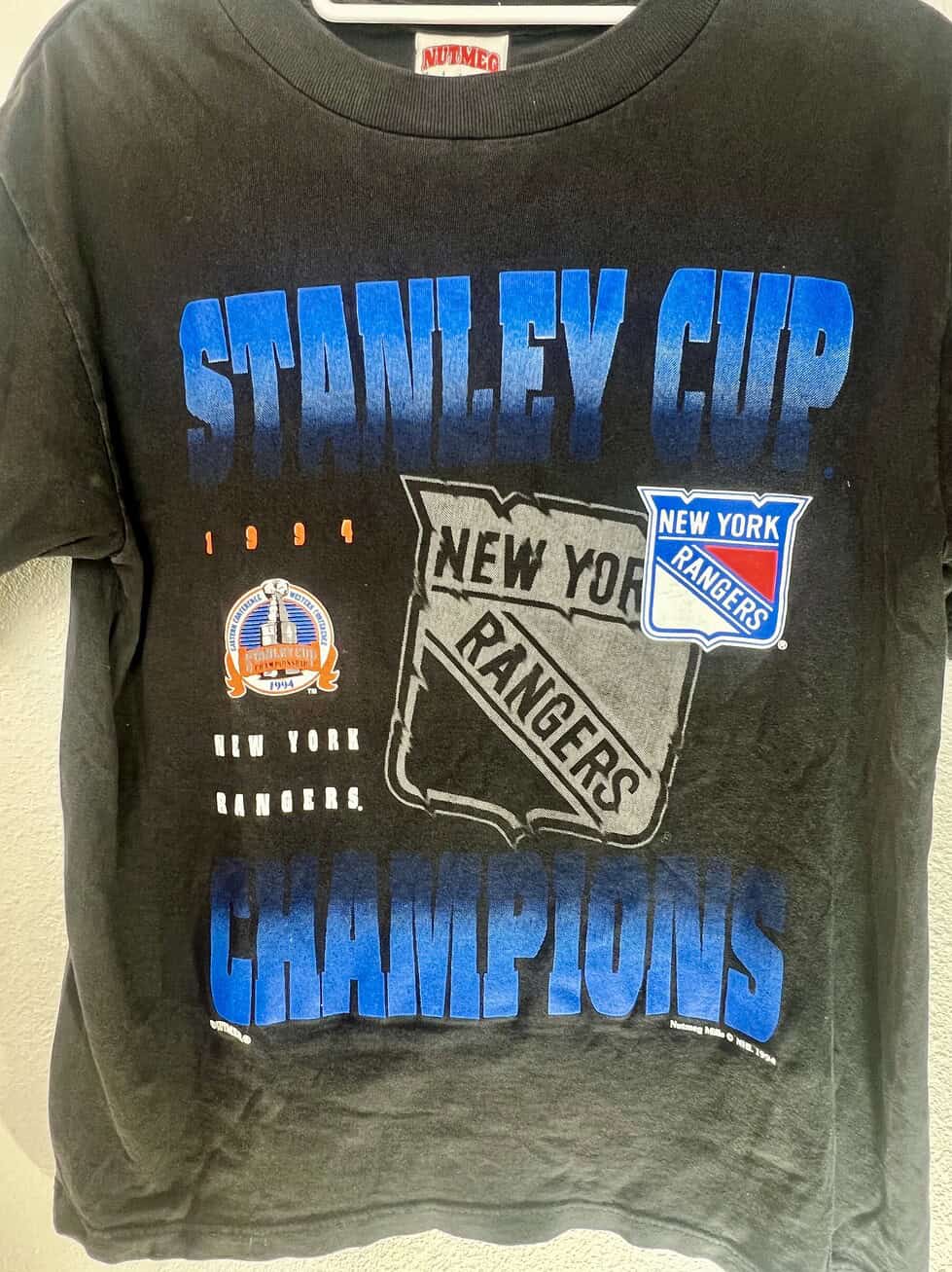 Close-up of Nutmeg tag and Rangers ‘94 Cup graphic print on black tee