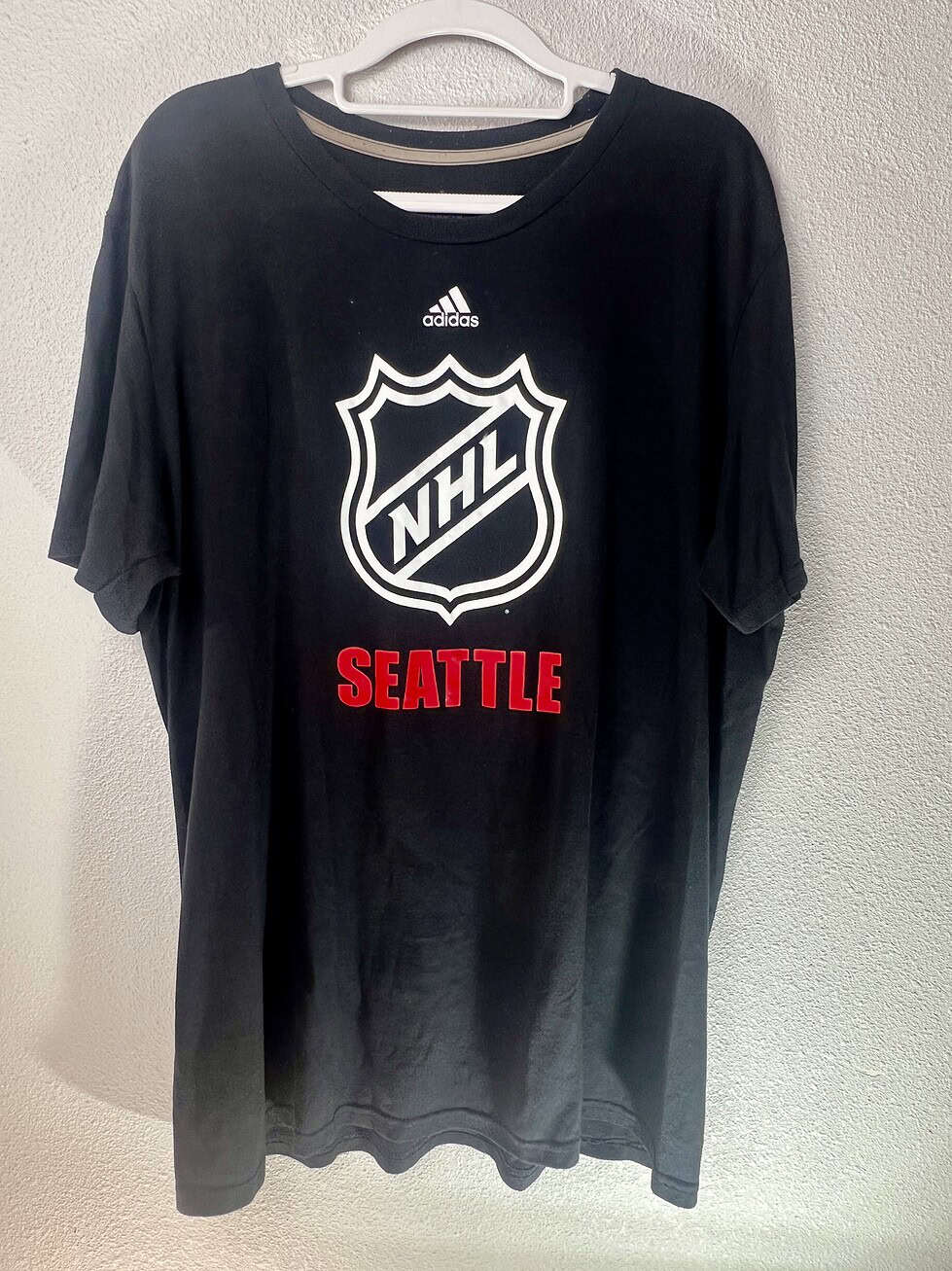 Black Adidas Climalite NHL t-shirt with white NHL shield and red “Seattle” text, size XL