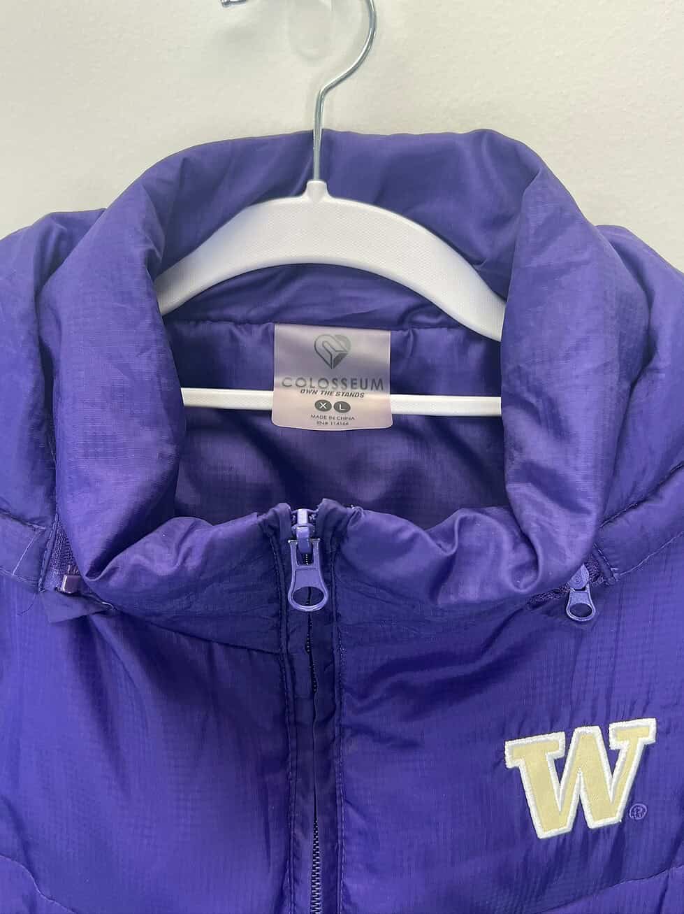 Close-up of embroidered “W” logo and brand label on UW vest