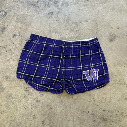 Front view of purple plaid flannel UW Huskies shorts with embroidered gold-trimmed W logo.