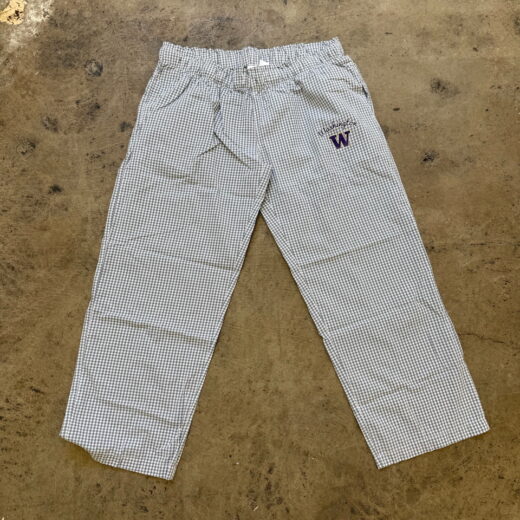 Gingham University of Washington lounge pants with "W" logo and "Washington" script on left hip, laid flat on concrete.