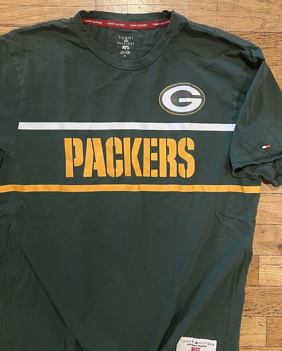 Close-up of NFL x Tommy Hilfiger woven patch on Packers T-shirt