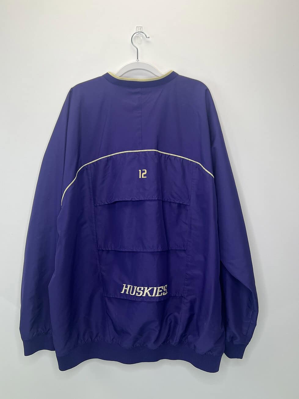 Back of pullover showing embroidered “12” and “Huskies” with rear ventilation flap