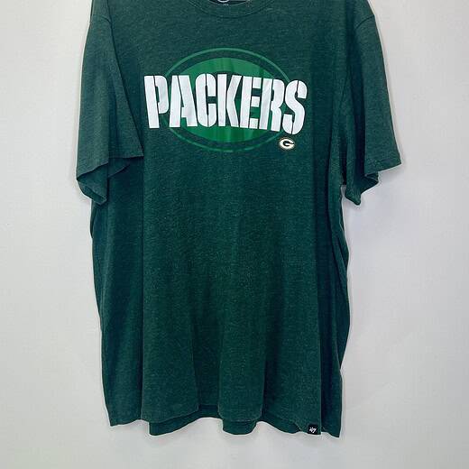 Front and close-up views of a green '47 Brand Green Bay Packers T-shirt in size 2XL, featuring bold “PACKERS” lettering across the chest and a vintage heathered texture.