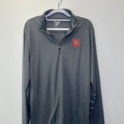 Gray long-sleeve quarter-zip pullover with Portland Thorns FC crest on left chest, displayed on hanger against white background.
