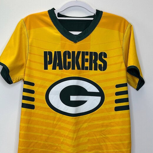 Front of reversible Packers youth flag football jersey in gold with Packers “G” logo