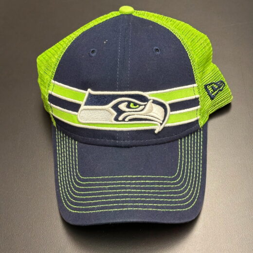 Seattle Seahawks trucker hat by New Era in navy and neon green, front view with embroidered logo